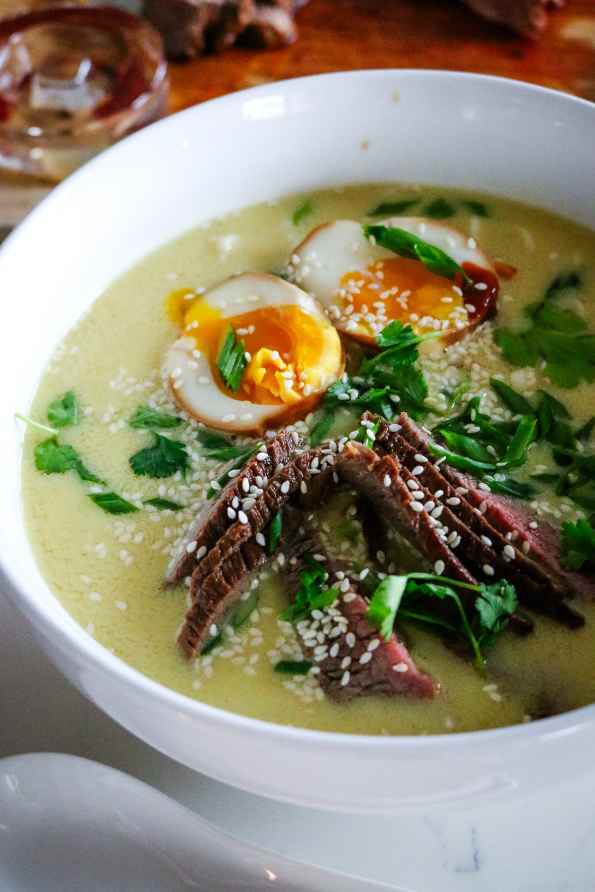 ramen with steak, noodles, and soft-boiled egg with green onions.
