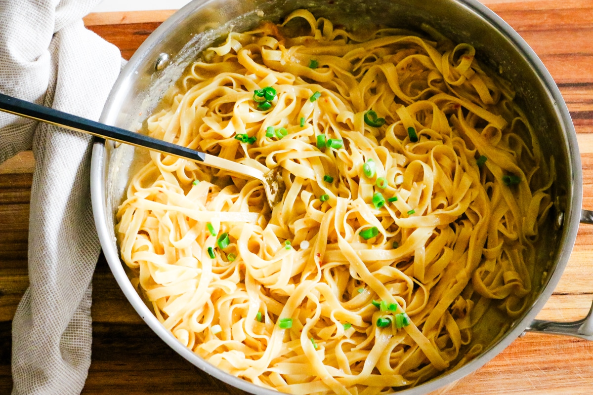 miso pasta in a stainless steel deep pan with a spoon and napkin on the side.