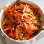 shaved carrot ribbons, thinly sliced celery and bell pepper in a white bowl.