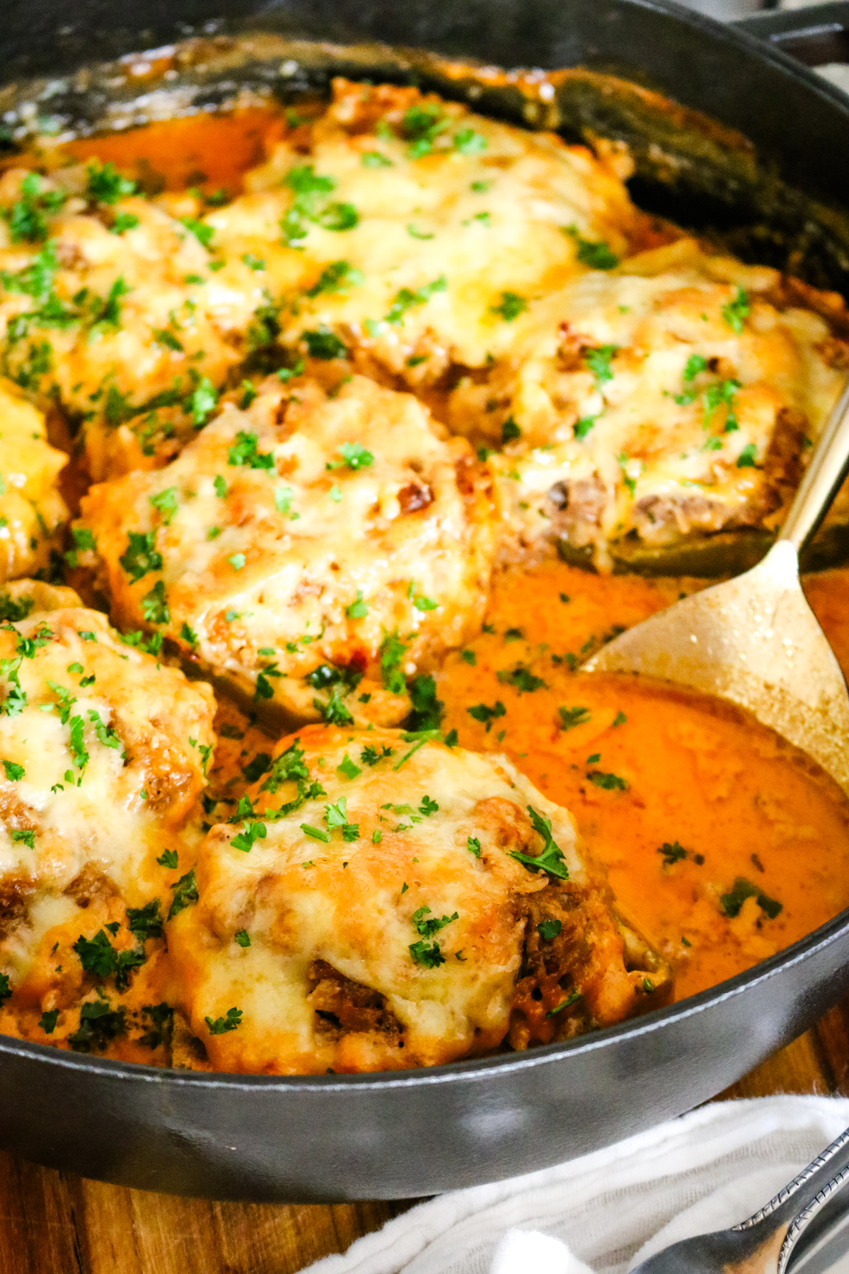 stuffed bell peppers in a deep pan with a creamy tomato sauce.