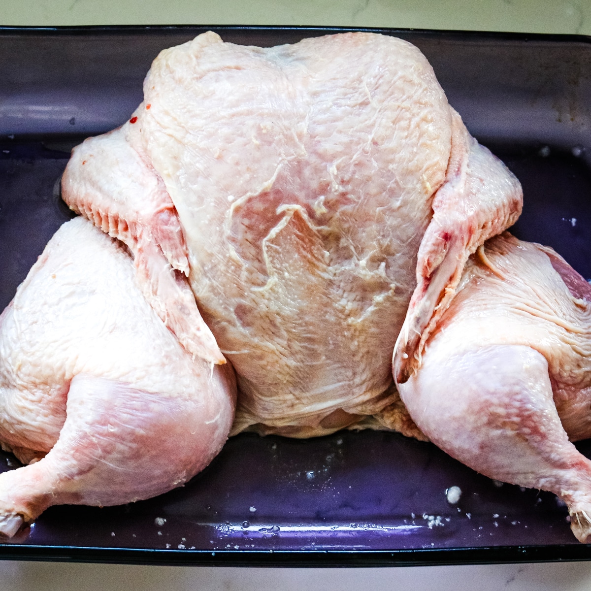 dry brined chicken in a baking dish.
