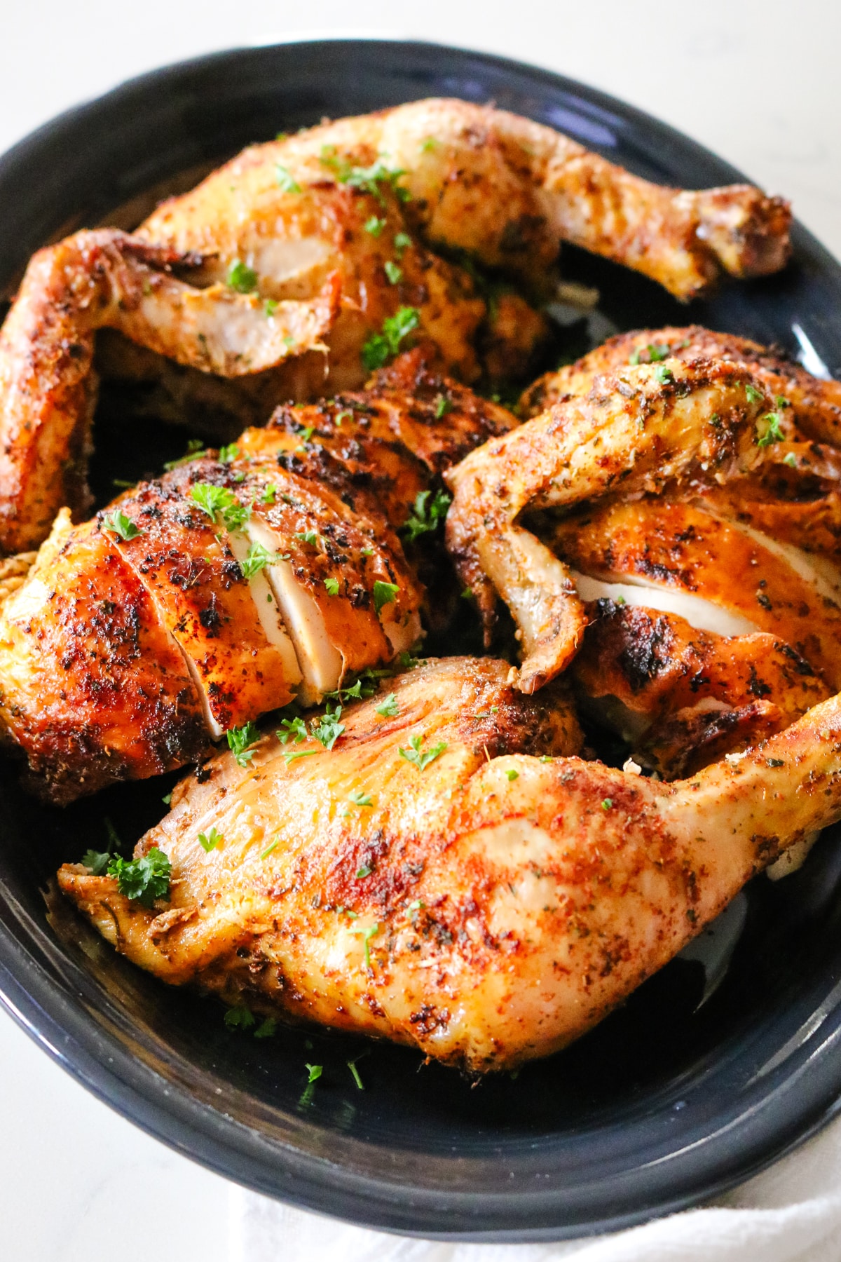 roast chicken on a black platter.