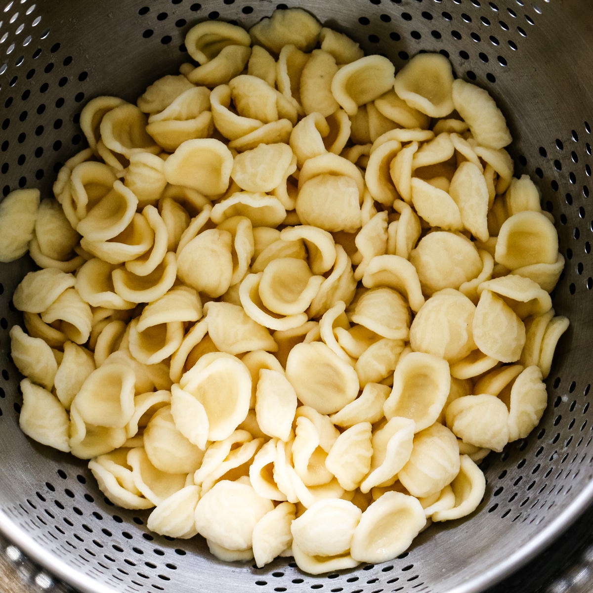 pasta in a metal strainer.