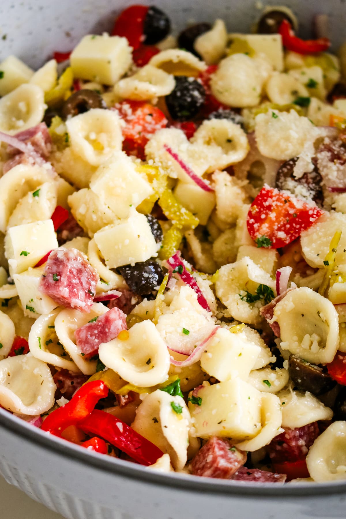 closeup of italian pasta salad in a white bowl.