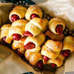 pigs in a blanket on parchment paper in a tray.
