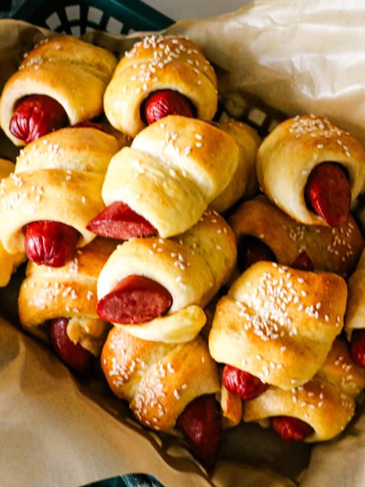 pigs in a blanket on parchment paper in a tray.