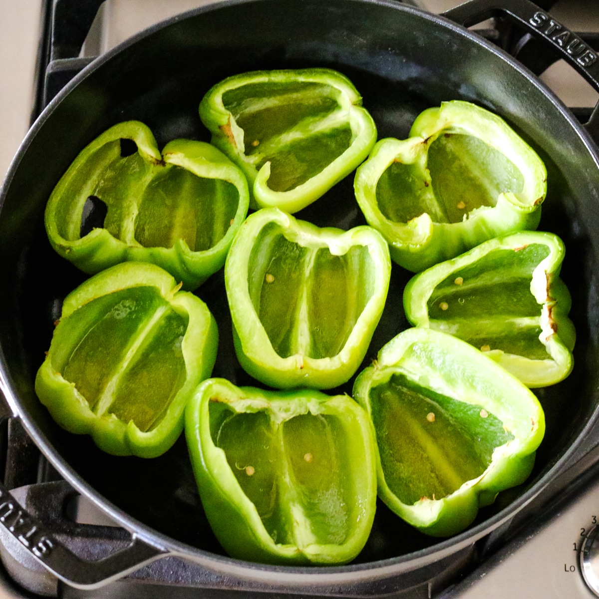 halved green bell peppers in a deep saute pan.