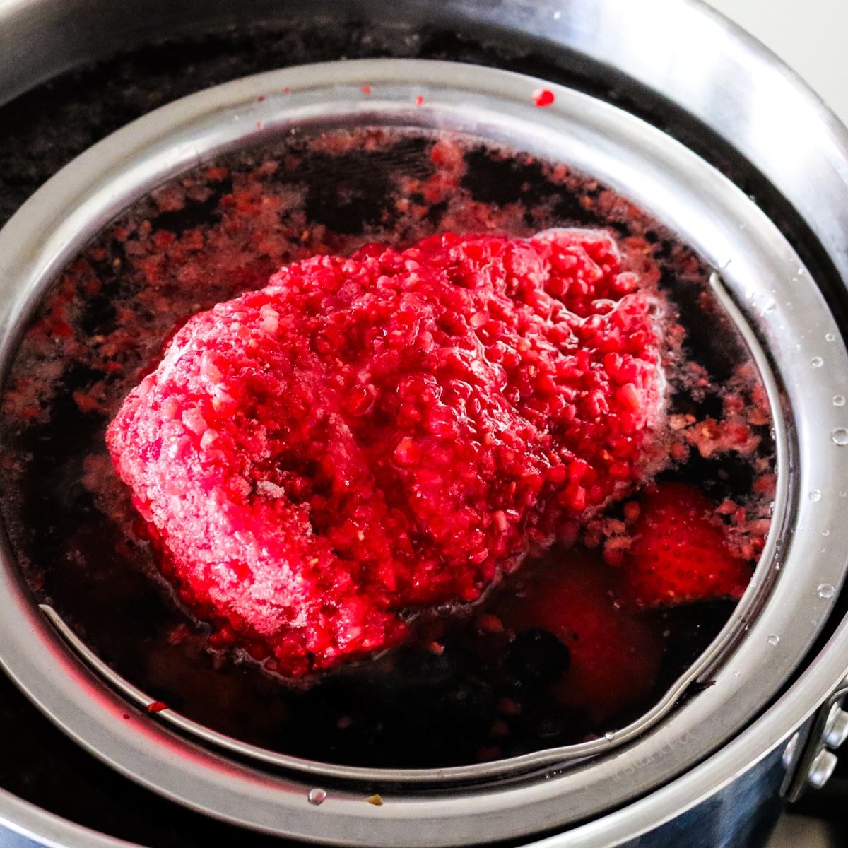 Frozen berries added to a pot of water for making kompot.