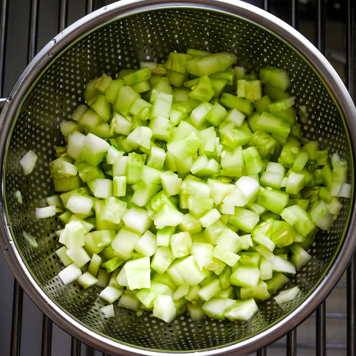 diced cucumbers in a metal strainer