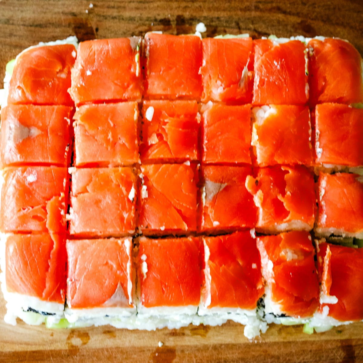 smoked salmon sushi on a wooden board.