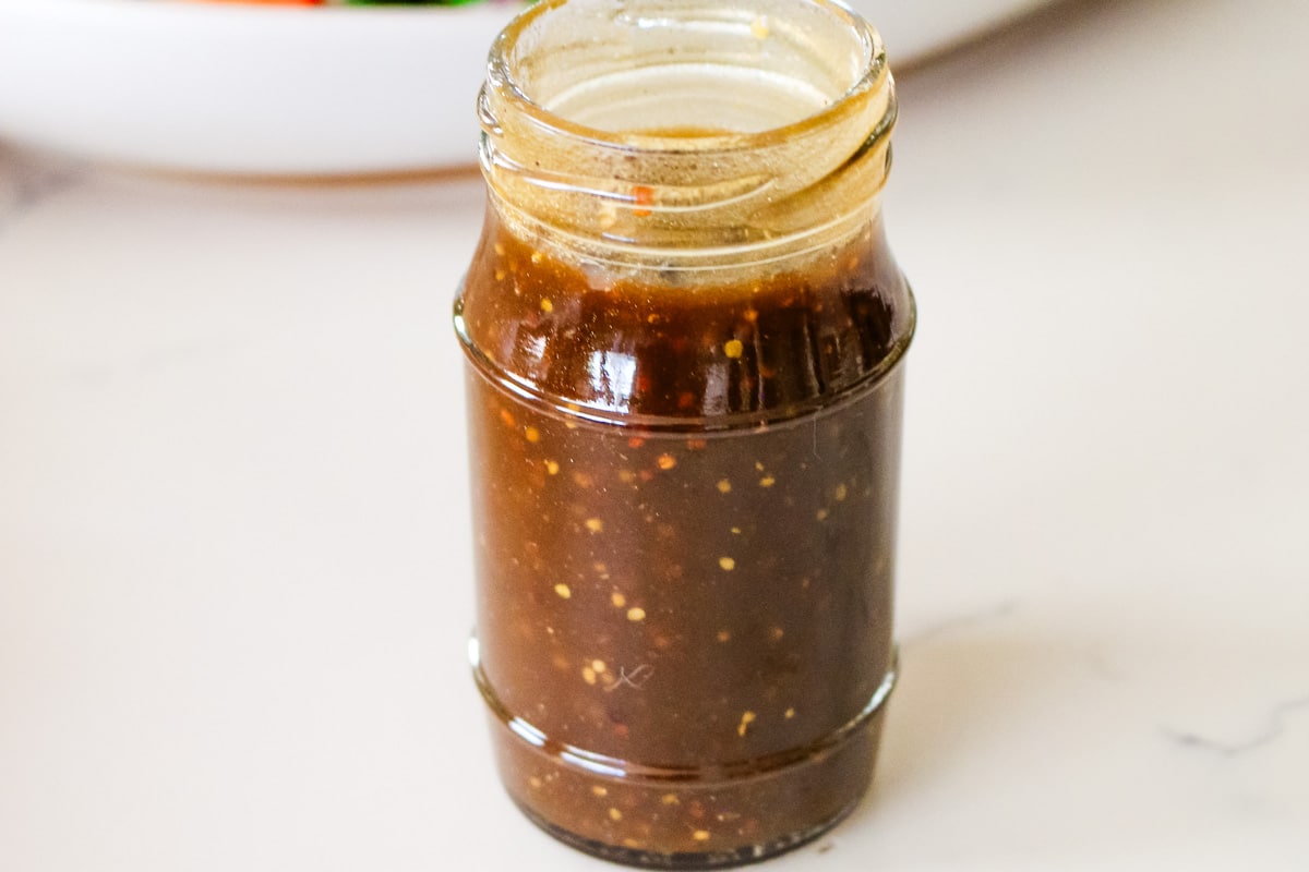 homemade balsamic vinaigrette dressing in a glass jar on a countertop.