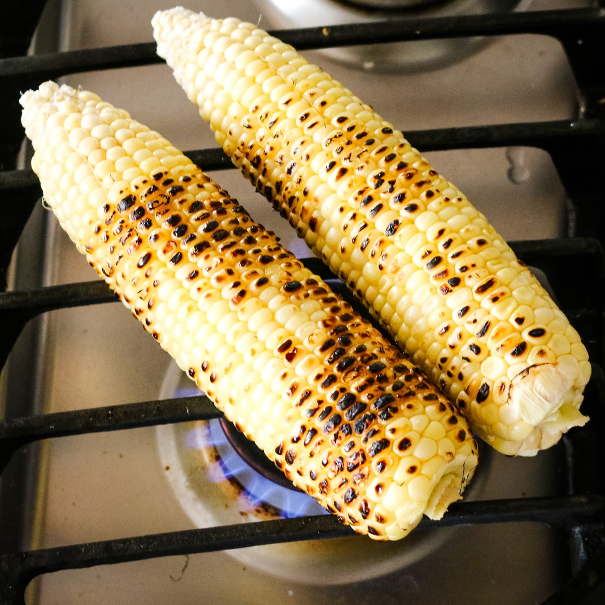 photo of corn getting cooked on a stove top.
