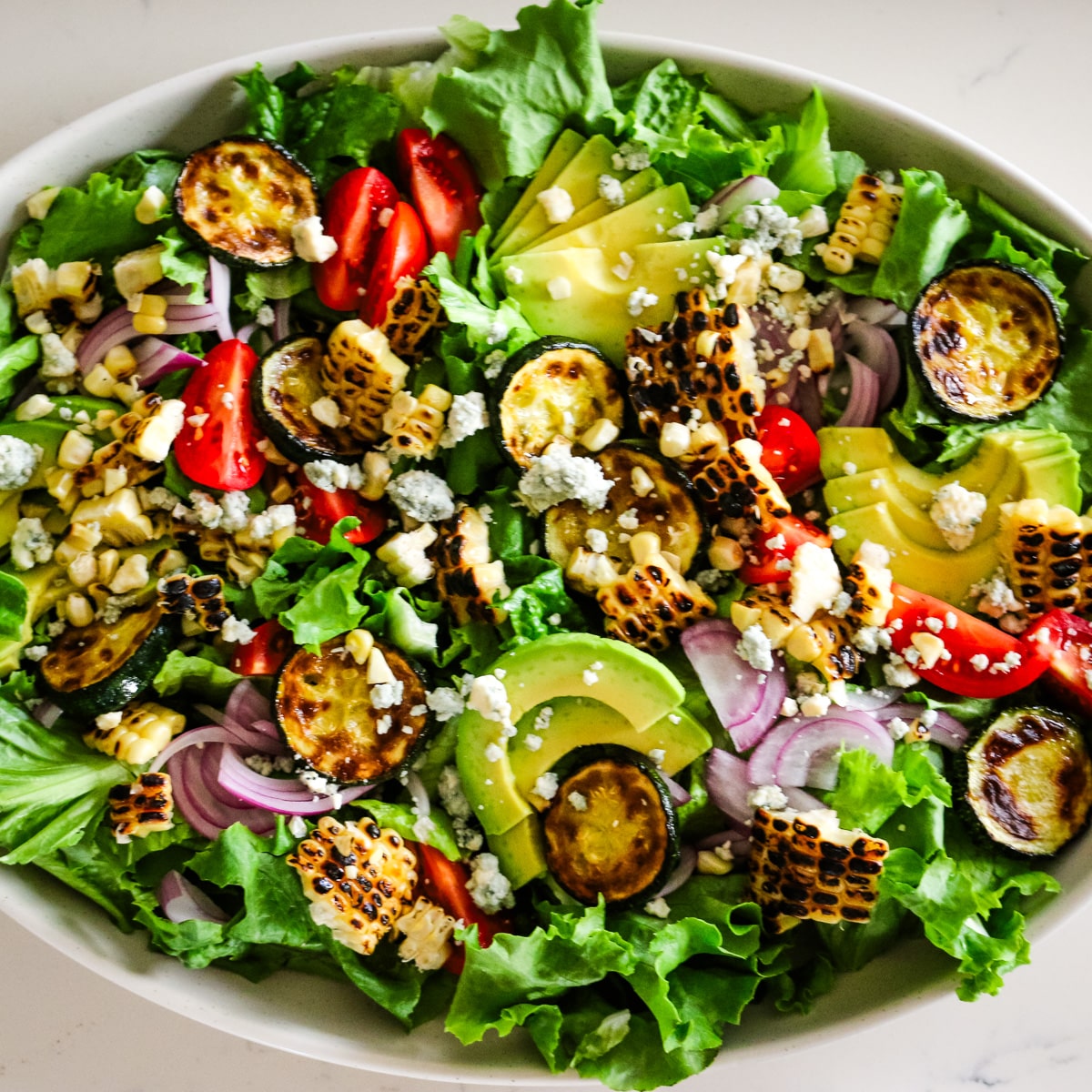 photo of steak salad in a white bowl.